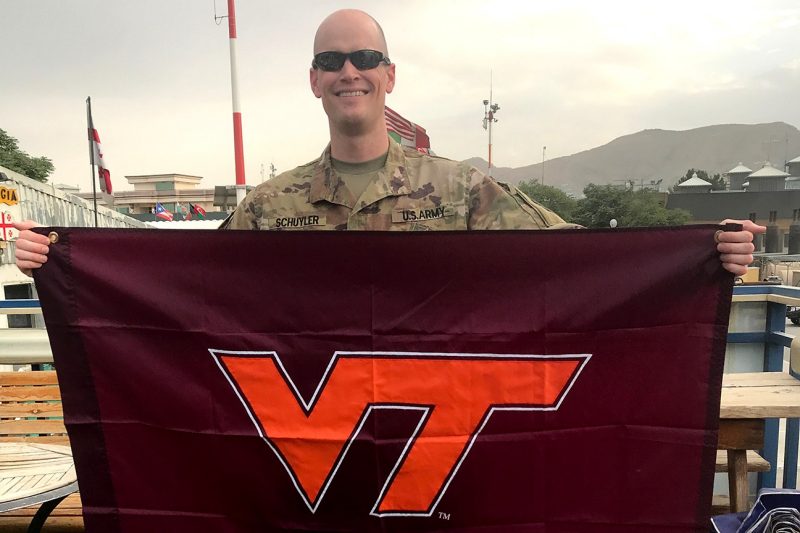 U.S. Army Maj. Stephen Schuyler holds a Virginia Tech flag.