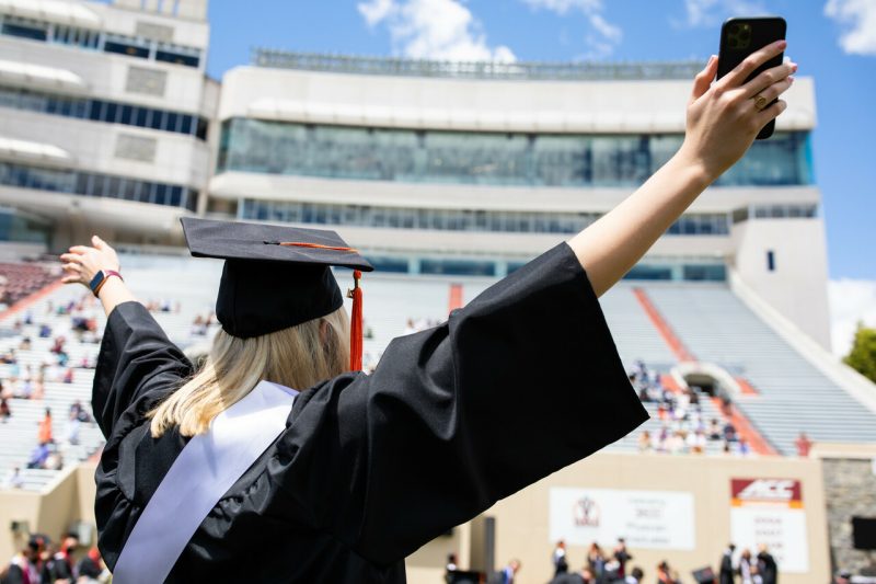 A graduate cheers during a commencement ceremony in Lane Stadium